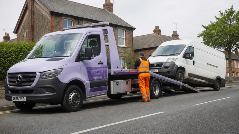 White van being winched onto a 3.5t flatbed recovery truck